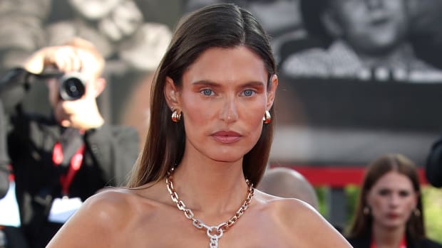 Bianca Balti poses in a gold chainlink necklace and sports a slicked back down-do.
