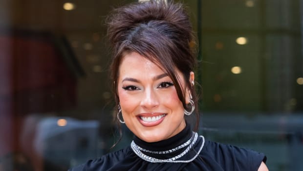 Ashley Graham poses in a black high-neck dress and diamond necklaces.
