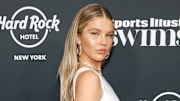 Model Ellie Thumann wears a white silk dress and silver jewelry and sports a slicked-back hairdo.