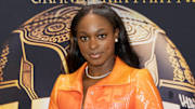 Sloane Stephens poses in an orange sparkly blazer jacket and silver diamond necklace.