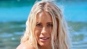 Abby Dahlkemper poses in front of the vibrant green-blue ocean water.