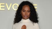 Kayla Nicole poses in a white knit dress in front of a white backdrop.