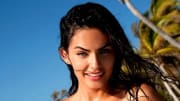 Alyssa Miller poses before vibrant green palm trees sporting wet hair.