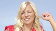 Lacy Schnoor poses in a red puffy vest and smiles for the camera.