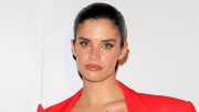Sara Sampaio poses in a bright red blazer and glossy pink lip.