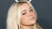 Olivia Dunne looks over her shoulder at the camera wearing her bright blonde hair in a wave.