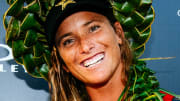 Courtney Conlogue wears a green braided hat and smiles for the camera.