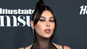 Lauren Cahn poses in a high-neck black mesh dress and a slicked-back bun.