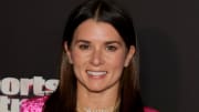 Danica Patrick poses in a pink velour blazer and smiles for the camera.