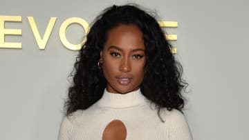 Kayla Nicole poses in a white knit dress in front of a white backdrop.