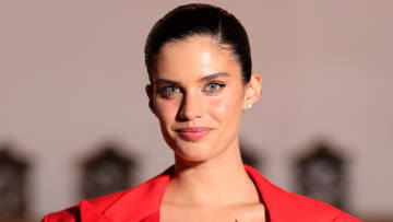 Sara Sampaio poses in a bright red jacket and slicked-back hairdo.