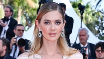 Megan Williams poses in a pale pink and cream dress and silver drop earrings.
