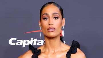 Skylar Diggins-Smith poses for the camera in a ruffled black dress.