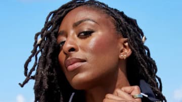 Nneka Ogwumike poses in a black one-piece and looks down at the camera.