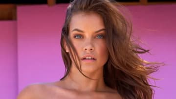 Barbara Palvin poses in a strapless swimsuit and looks intently at the camera.