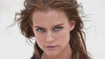 Kim Cloutier poses on the beach with her hair in a messy up-do.