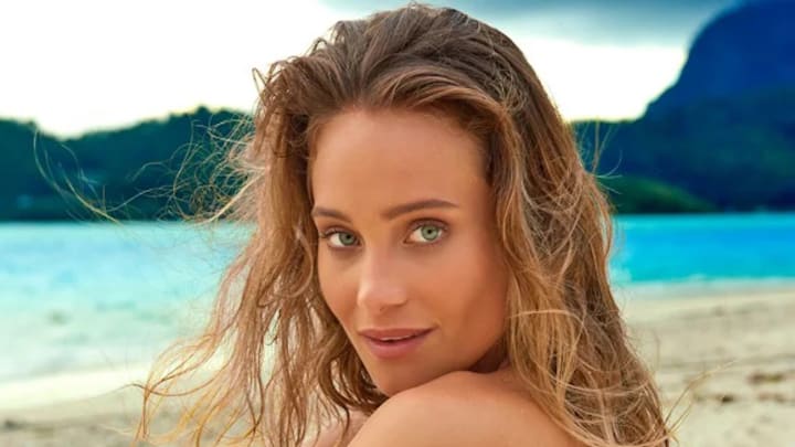 Hannah Jeter sits on the beach and looks to her side at the camera. Hannah Jeter sits on the beach and looks to her side at the camera.