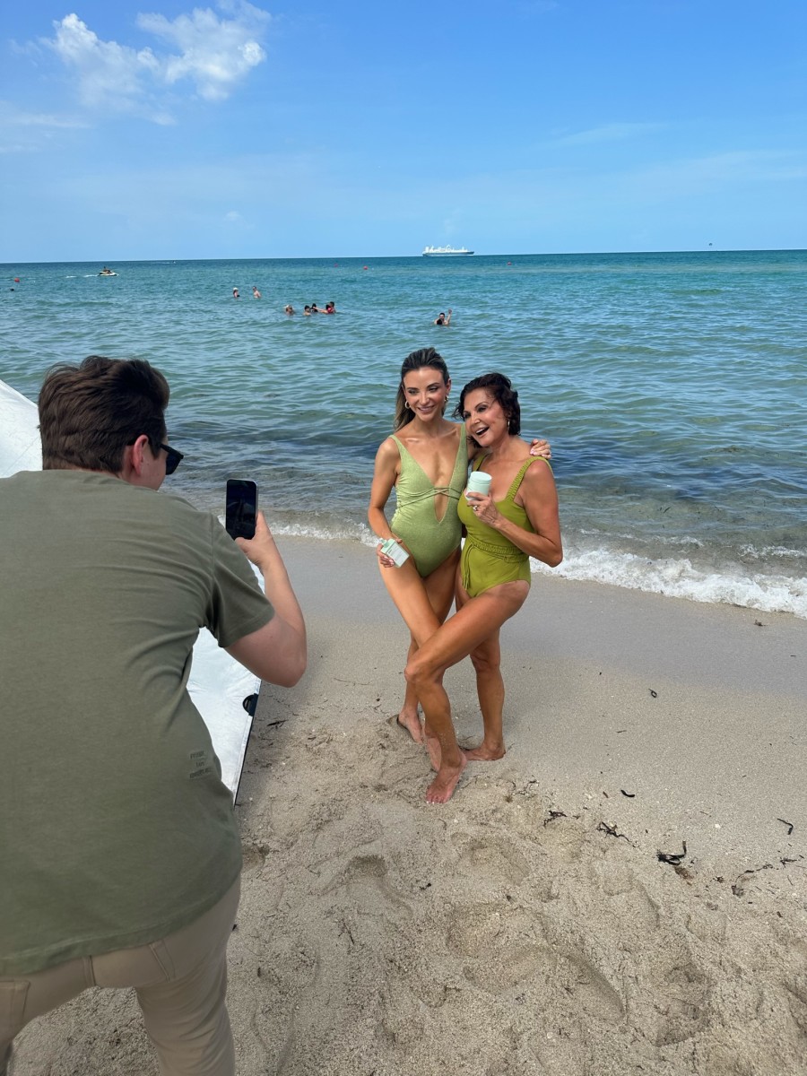 Dani Austin and Anna Marie Austin on the beach holding Divi products.