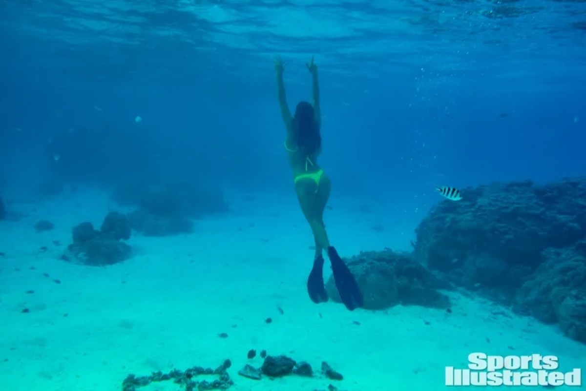 Hannah Jeter swims through the clear waters of Tahiti in a neon bikini.