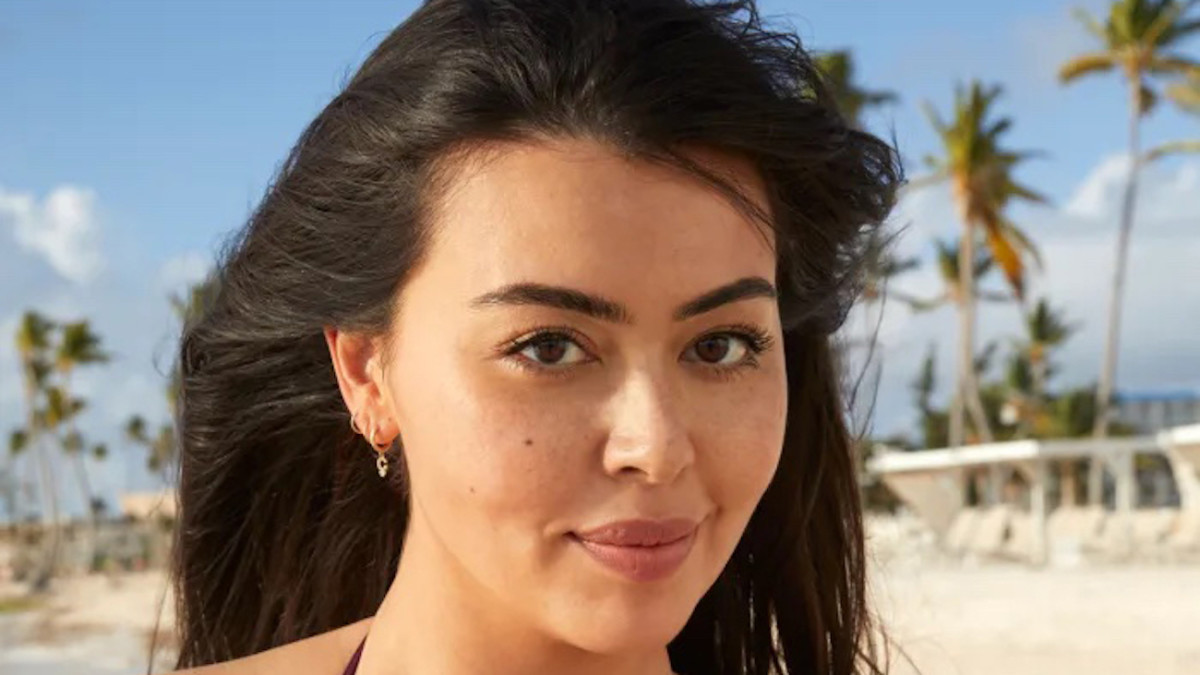 Lauren Chan poses in front of palm trees and smiles at the camera.