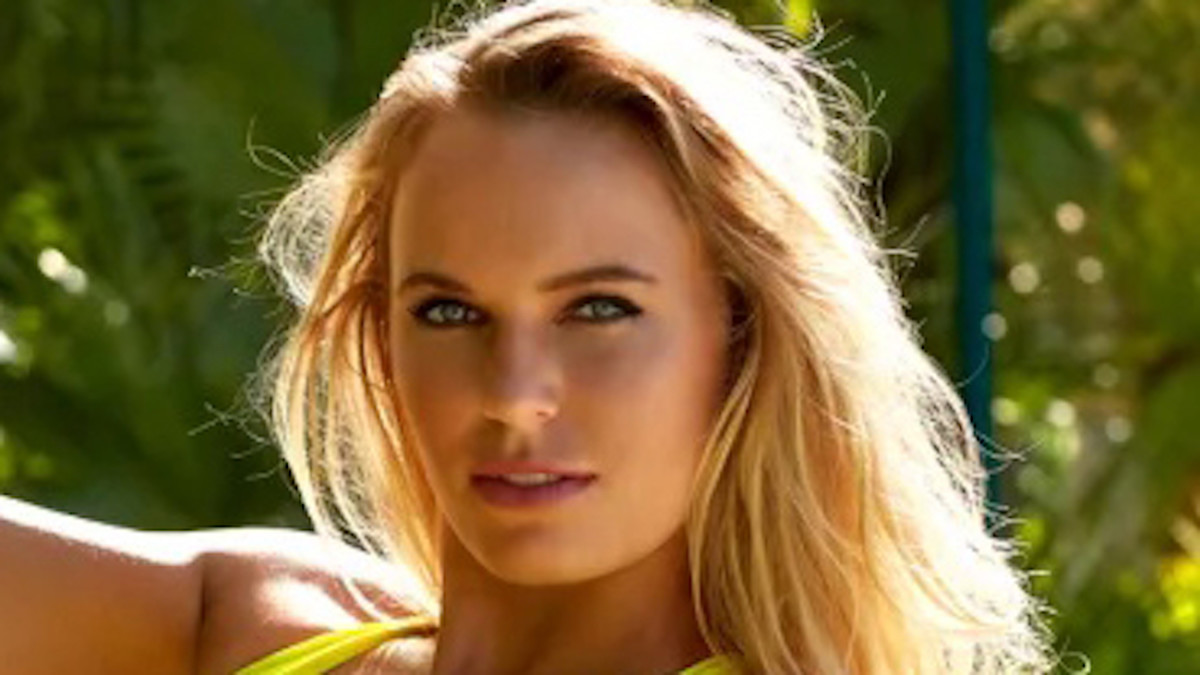 Caroline Wozniacki smiles in a neon green swimsuit and wears her blonde hair down.