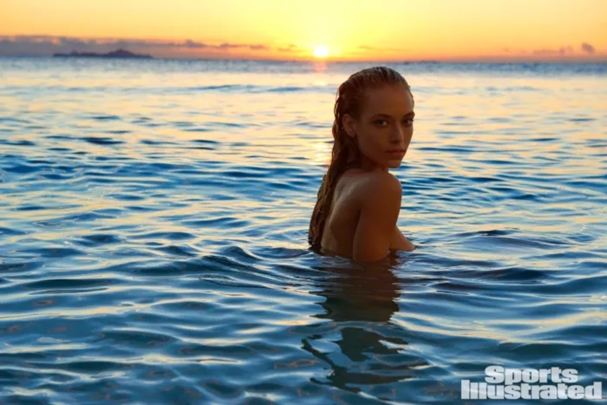 Hannah Ferguson poses in the ocean at sunset.