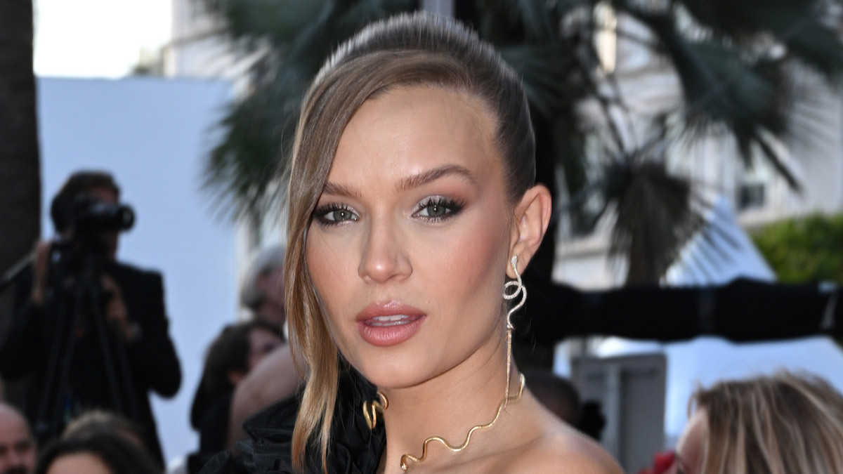 Josephine Skriver poses in silver serpent earrings and a gold choker necklace.