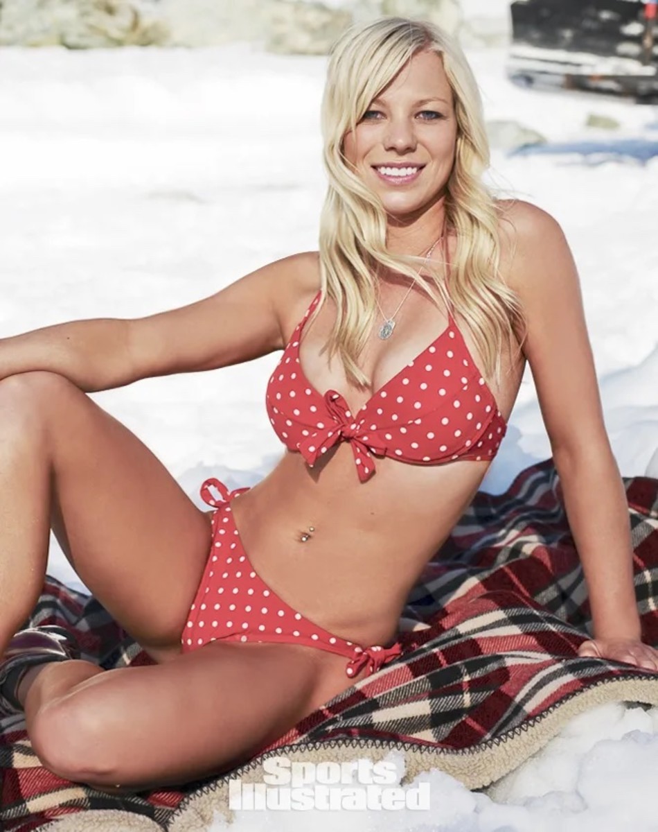 Lacy Schnoor sits on a red plaid blanket and wears a red bikini with white polka dots.