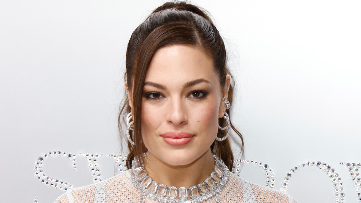 Ashley Graham poses in a dress made of Swarovski crystals and smiles for the camera.
