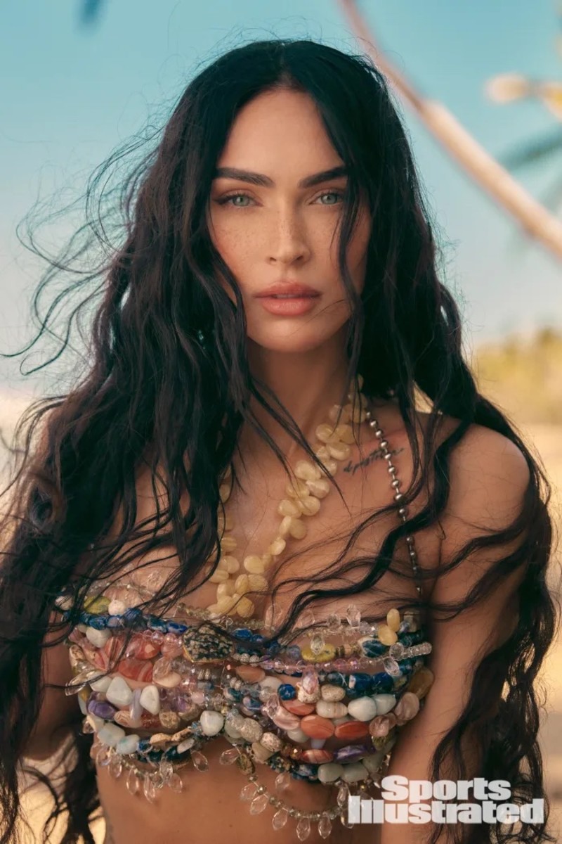 Megan Fox poses in a colorful beaded bikini top and wears her hair in a black beach wave.