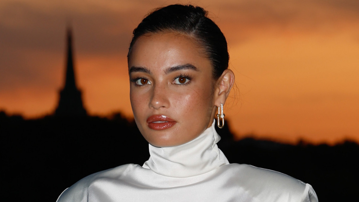 Kelsey Merritt poses in front of the sunset in a white satin gown.