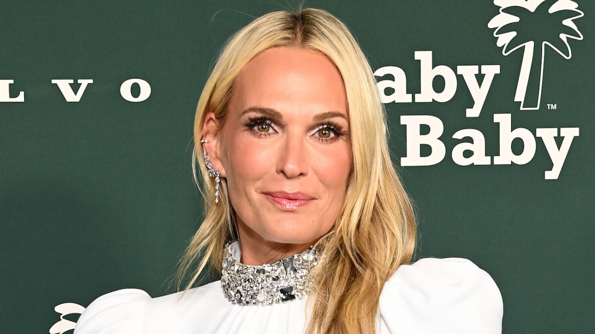 Molly Sims poses in a white gown with a bedazzled collar.