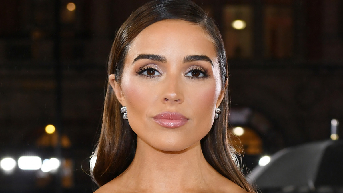 Olivia Culpo sports a slicked-back down-do and glittery eye makeup.