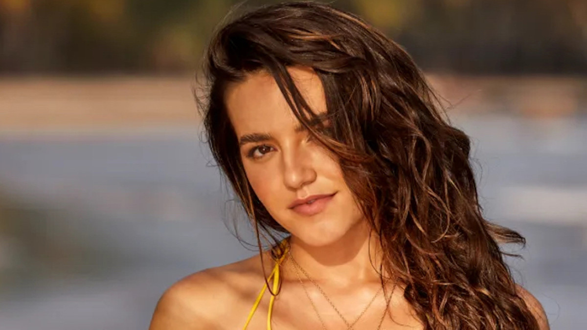 Mady Dewey poses in a yellow string bikini and a wavy down-do.