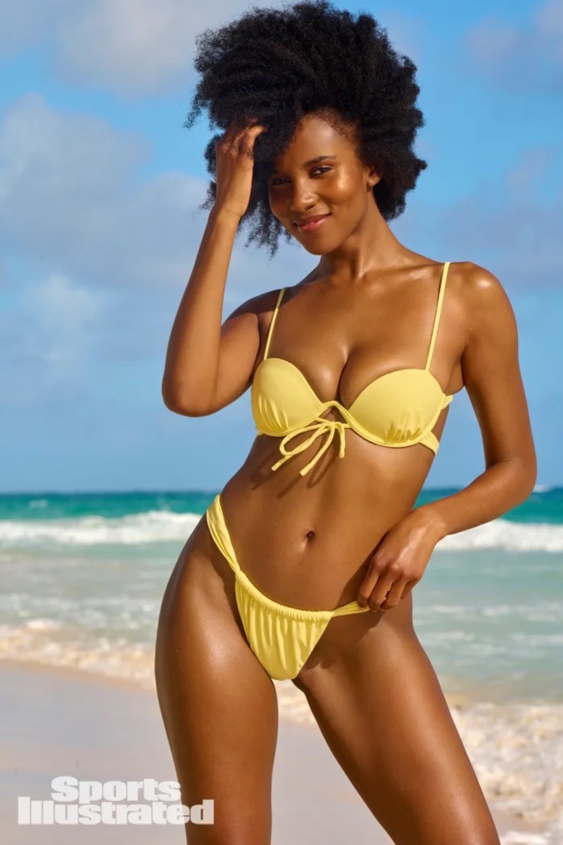 Drew Dorsey stands on the beach in a yellow underwire bikini set.