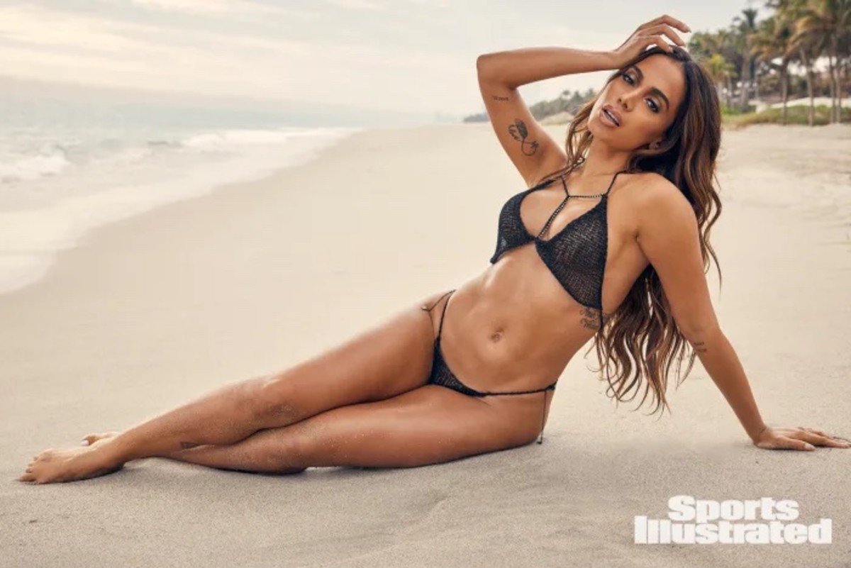 Anitta lays on the sand in a black knit bikini set.